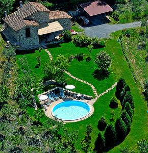 MontecastelliにあるVilla esclusiva in Toscana con piscina privataのスイミングプール付きの家屋の空中ビュー