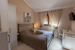 a bedroom with a bed and a desk and a window at Guest House Navetta in Fažana