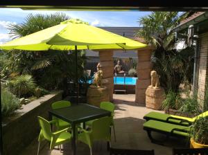 a table and chairs under a yellow umbrella at B&B wellness Sea Nat voor Naturisten in Oostduinkerke