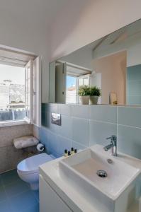 a bathroom with a white sink and a toilet at Casa das Laranjas in Porto
