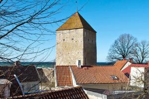 a building with a tower on top of a city at Casa Kruttornet & Villa Fiskarporten in Visby