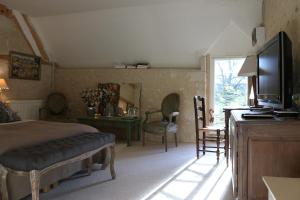 a bedroom with a bed and a flat screen tv at Le bourgis in La Chapelle-Montligeon