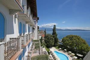 a view from the balcony of a building with a swimming pool at Hotel Savoy Palace in Gardone Riviera