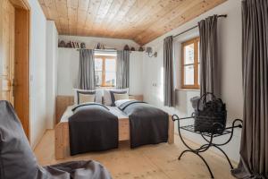 Chalet Hafling Leckplått في أفيلينغو: غرفة نوم بسريرين وسقف خشبي