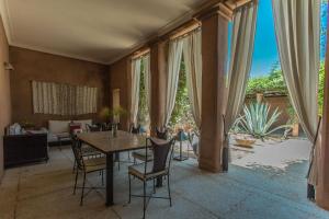 a dining room with a table and chairs and a couch at Villa Akhdar 18 in Ben Larbi