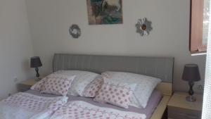 バラトンフェニヴェシュにあるFenyves Beach Houseのベッドルーム1室(ピンクと白の枕が備わるベッド1台付)