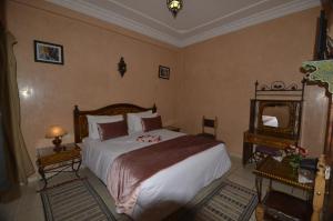 a bedroom with a large bed and a mirror at Essaouira Wind Palace in Essaouira