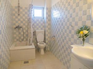 a bathroom with a toilet and a sink and a tub at Hostel Kapa in Hvar