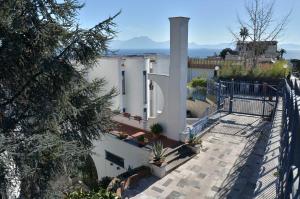 une maison blanche avec un portail et une clôture dans l'établissement La Casetta di Posillipo, à Naples