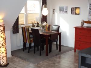 a dining room with a wooden table and chairs at Kranichnest in Hohwacht