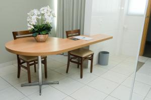a table that has a vase with flowers on it at Ímpar Suítes Cidade Nova in Belo Horizonte