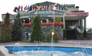 a hotel with a fountain in front of a building at Hotel President in Arad