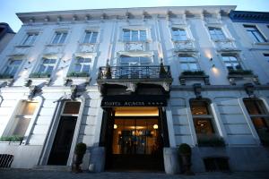 a large white building with a balcony in front of it at Hotel Acacia in Bruges