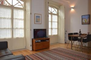 un salon avec une télévision et une table dans l'établissement Oporto Like Home IV - Mezzanine, à Porto