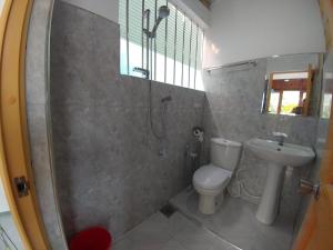 ein Bad mit einer Dusche, einem WC und einem Waschbecken in der Unterkunft Sun Hill Home in Weligama