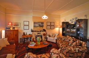 a living room with two couches and a table at Guinea Fowl Lodge in Knysna