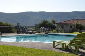 una piscina con due sedie a sdraio di Casa dos Avós by Eira dos Canastros a Espindelo