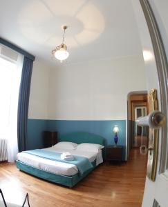 Schlafzimmer mit einem Bett mit blauer Wand in der Unterkunft Town House Messina Paradiso in Messina