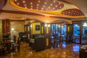 a restaurant with chairs and tables and a ceiling with lights at Morfeas Guesthouse in Kato Loutraki