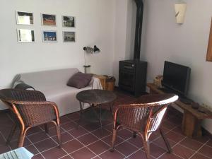 a room with a bed and two chairs and a tv at Casa rural La Sabina in Fortanete