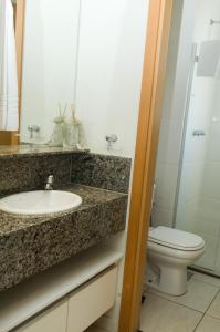 uma casa de banho com um lavatório e um WC em Ímpar Suítes Cidade Nova em Belo Horizonte