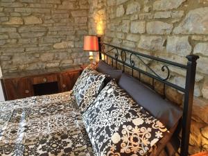 a bedroom with a bed and a stone wall at Casa Kuraj in Sestino