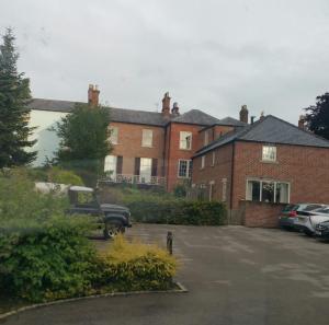 un camion parcheggiato di fronte a un edificio di mattoni di Madge House Ashbourne ad Ashbourne