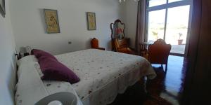 Dormitorio con cama con almohada morada en Casa La Caldera, en Firgas