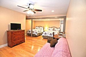 a bedroom with two beds and a flat screen tv at Peach Tree Inn & Suites in Fredericksburg