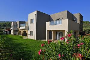 a house on a hill with pink flowers at Krotiri Resort in Agios Nikolaos