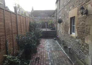 un callejón con una pared de piedra y una escalera en The Jolly Huntsman en Chippenham
