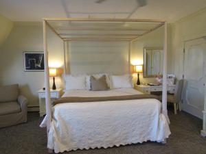 - une chambre avec un grand lit à baldaquin blanc dans l'établissement Carter House Inns, à Eureka