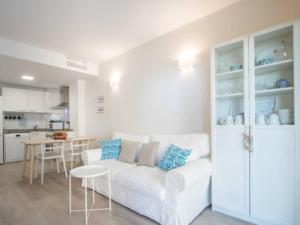 ein Wohnzimmer mit einem weißen Sofa und einer Küche in der Unterkunft Sol y playa en San Juan Alicante in Alicante