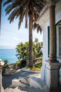 ein weißes Haus mit Palmen und dem Meer in der Unterkunft Town House Messina Paradiso in Messina