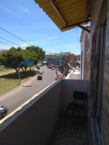 una silla sentada en el balcón de un edificio con una calle en Duplex com dois Quartos en Salvador