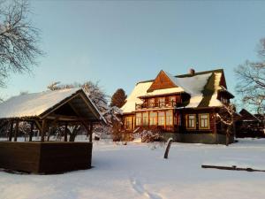 dom pokryty śniegiem z altaną w obiekcie Górska Leśniczowka w Zubrzycy Górnej