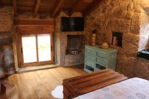 a room with a bed and a window and a television at Bodega rural tipo loft in Ourense
