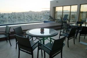 a restaurant with tables and chairs and a view of a city at Hotel Beaga Convention Expominas by MHB in Belo Horizonte