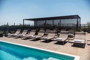 una fila de tumbonas junto a una piscina en KOS Pilar Hotel en Pilar