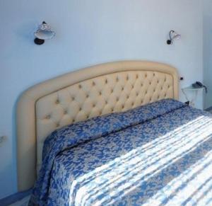 a bed in a bedroom with a blue wall at B&B Palazzo Pisani in Amalfi