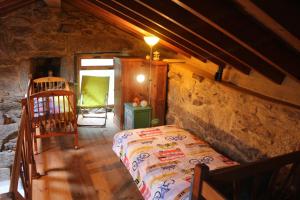 a bedroom with a bed in a stone house at Bodega rural tipo loft in Ourense