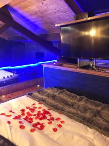 Zimmer mit einem Bett mit roten Rosen darauf in der Unterkunft Le Chalet Loft and Spa in Villeurbanne