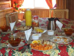 une table avec des assiettes de nourriture au-dessus dans l'établissement Pension Vaimano-Raivavae, à Vaiuru