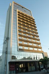 a tall building with a sign on the side of it at Hotel Beaga Convention Expominas by MHB in Belo Horizonte