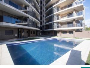 アリカンテにあるSol y playa en San Juan Alicanteのアパートメントの建物の前にスイミングプールがあります。