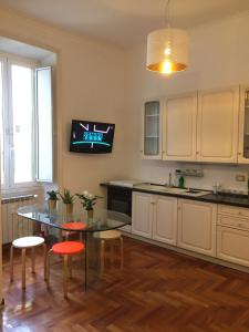 a kitchen with a table and a tv on the wall at Varese Guest House in Rome +21 photos