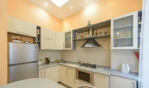 a kitchen with white cabinets and a stainless steel refrigerator at квартира in Kyiv +2 photos