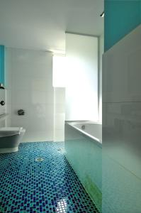 a bathroom with a blue tile floor and a bath tub at Krotiri Resort in Agios Nikolaos