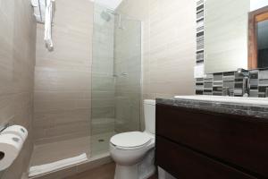 a bathroom with a toilet and a glass shower at Hotel Marea Vista in Ensenada