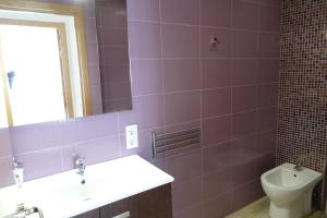 Baño púrpura con lavabo y aseo en Can Toni en Porto Cristo